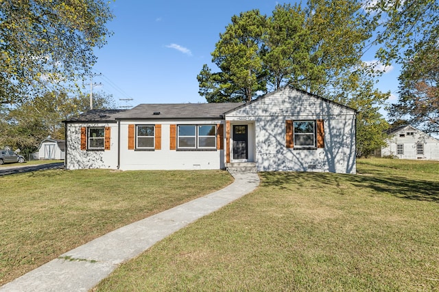 ranch-style home with a front yard and a shed