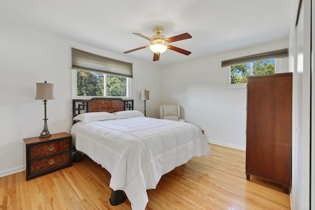 bedroom with multiple windows, light wood-type flooring, and ceiling fan