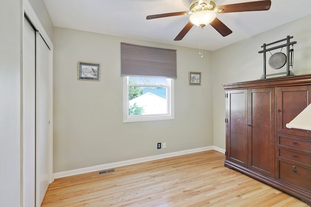 unfurnished bedroom with a closet, light hardwood / wood-style floors, and ceiling fan