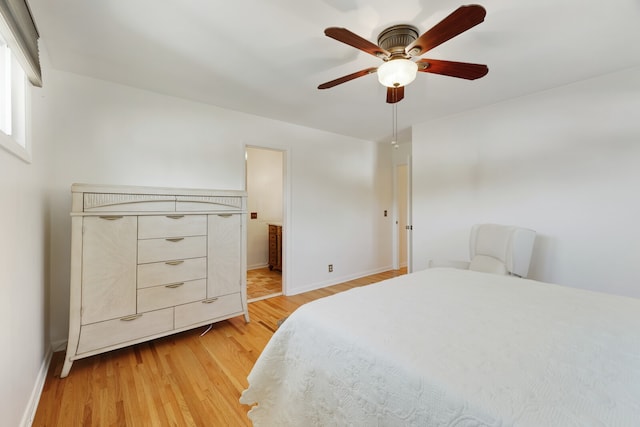 bedroom featuring connected bathroom, light wood-type flooring, and ceiling fan