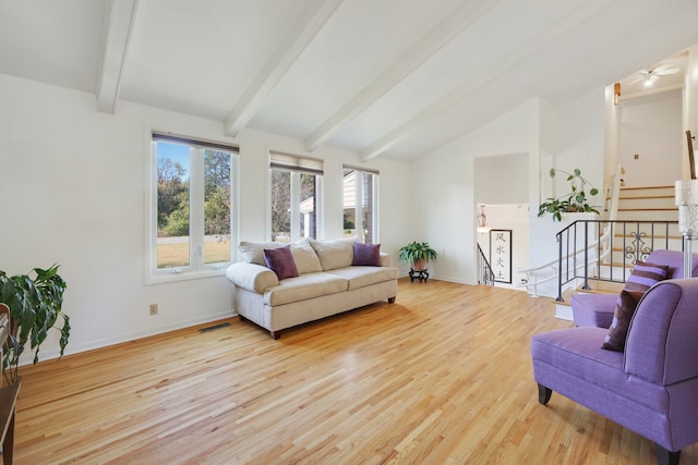 living room with lofted ceiling with beams and light hardwood / wood-style floors