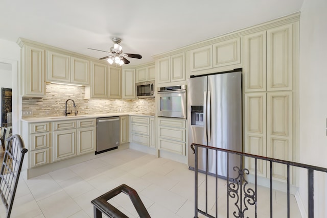 kitchen with appliances with stainless steel finishes, cream cabinetry, backsplash, and light tile patterned floors