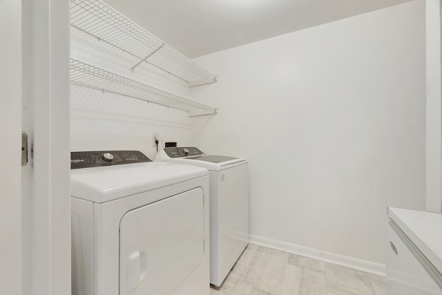 clothes washing area featuring washer and dryer and light wood-type flooring