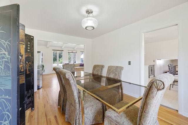 dining area with vaulted ceiling with beams and wood-type flooring