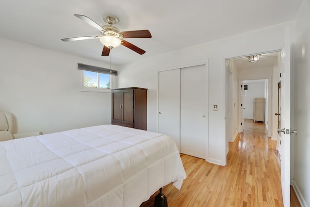 bedroom with light hardwood / wood-style floors, a closet, and ceiling fan