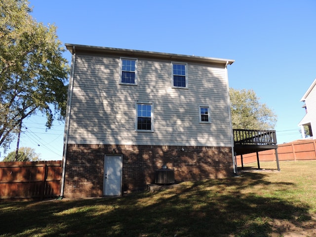 rear view of property featuring central AC and a yard