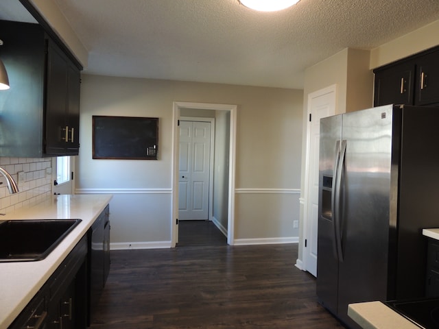 kitchen featuring black dishwasher, backsplash, dark hardwood / wood-style floors, stainless steel refrigerator with ice dispenser, and sink