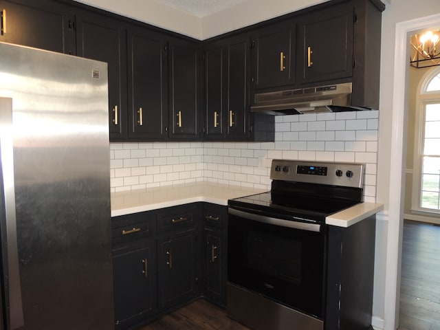 kitchen with stainless steel appliances, tasteful backsplash, dark hardwood / wood-style flooring, and an inviting chandelier