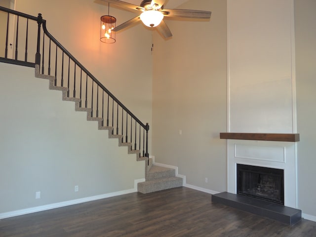 unfurnished living room featuring ceiling fan and dark hardwood / wood-style flooring