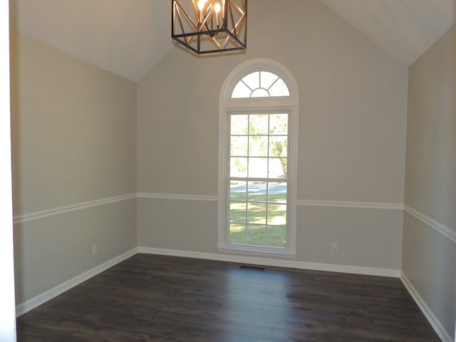 unfurnished room with an inviting chandelier, dark hardwood / wood-style floors, and vaulted ceiling