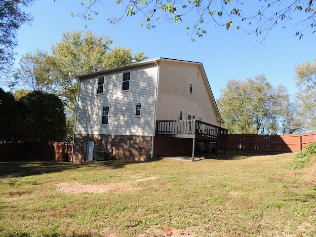 rear view of house with a yard, a deck, and central AC unit