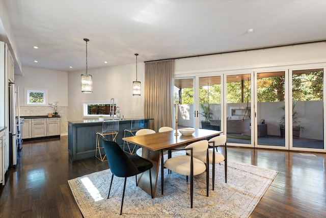 dining room featuring dark wood-type flooring, sink, and plenty of natural light