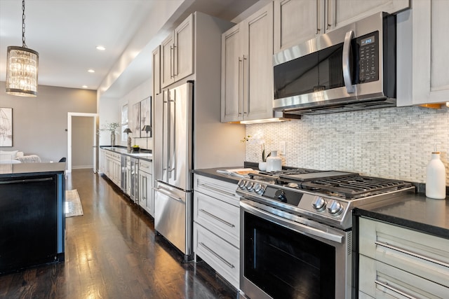 kitchen featuring backsplash, a chandelier, dark wood-type flooring, pendant lighting, and stainless steel appliances