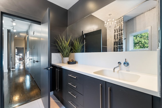 bathroom featuring vanity, a chandelier, and wood-type flooring