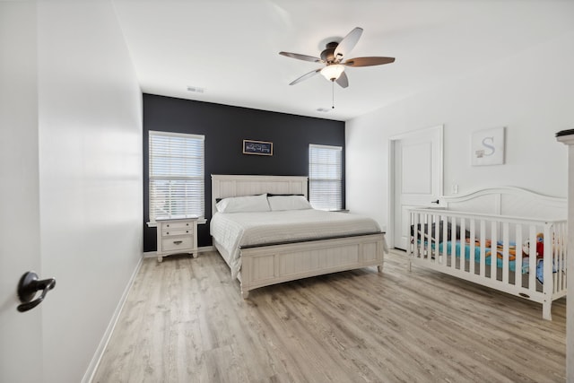 bedroom with light hardwood / wood-style floors and ceiling fan