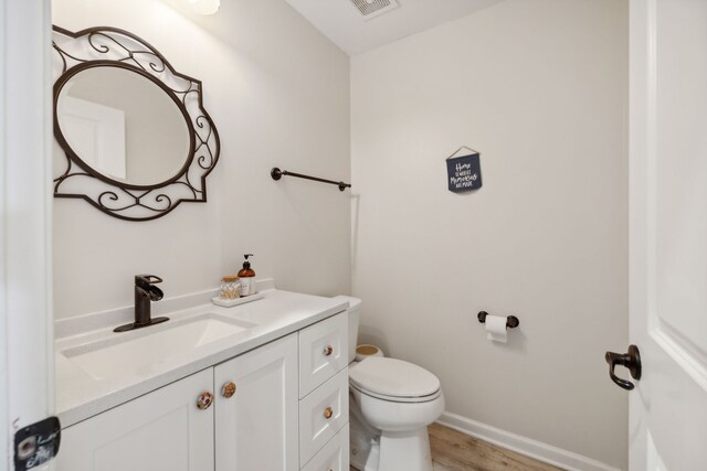 bathroom featuring vanity, toilet, and hardwood / wood-style flooring