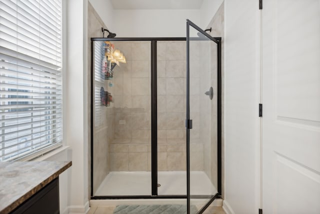 bathroom featuring vanity, a healthy amount of sunlight, and an enclosed shower