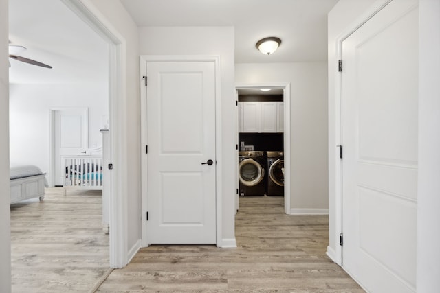 hall with light hardwood / wood-style flooring and washing machine and clothes dryer