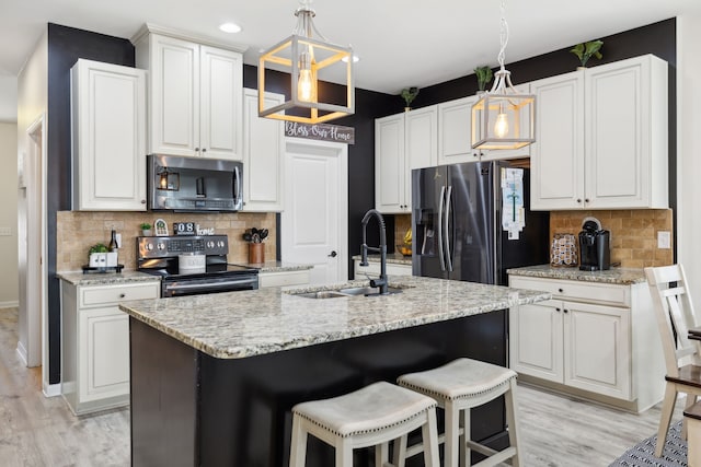 kitchen with a kitchen island with sink, appliances with stainless steel finishes, sink, and white cabinets