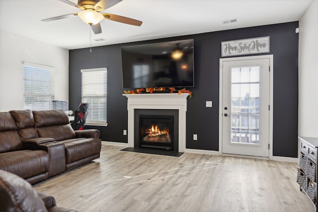 living room with light wood-type flooring and ceiling fan