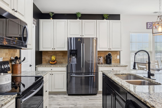 kitchen featuring black appliances, light stone countertops, light hardwood / wood-style flooring, and white cabinetry