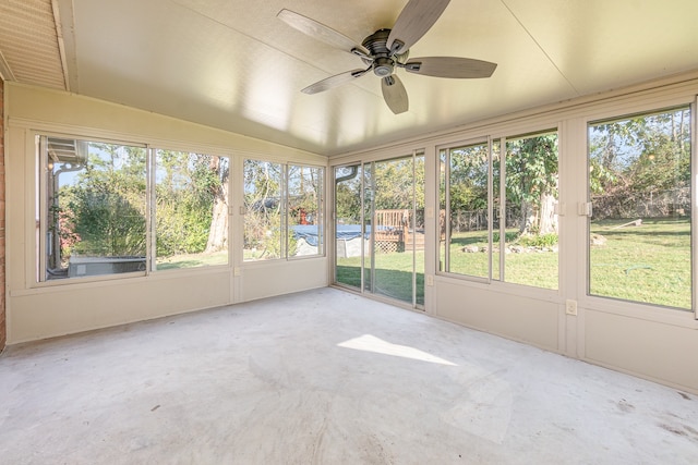 unfurnished sunroom with lofted ceiling, ceiling fan, and plenty of natural light