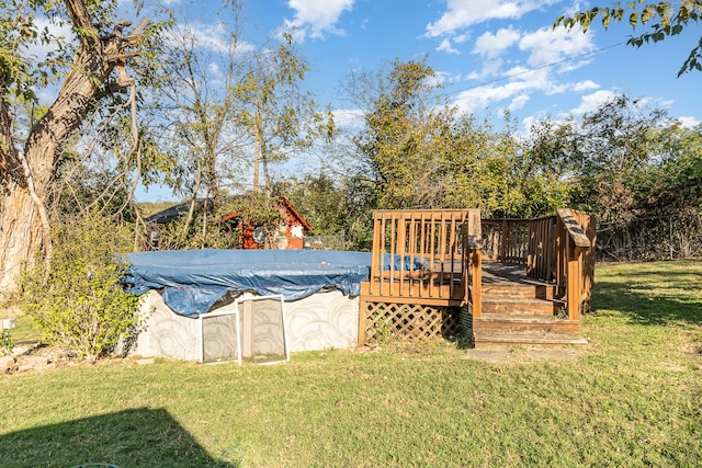 view of swimming pool featuring a deck and a lawn