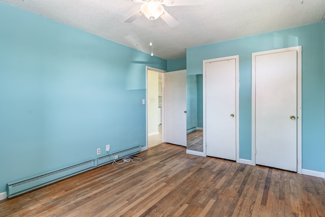 unfurnished bedroom with dark wood-type flooring, ceiling fan, a textured ceiling, and a baseboard heating unit