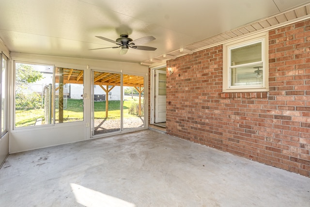 unfurnished sunroom featuring ceiling fan