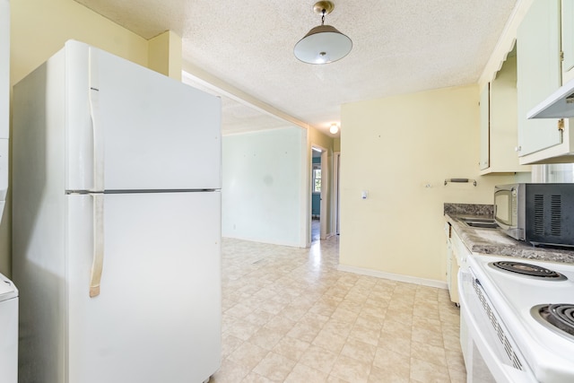 kitchen with white cabinetry, white fridge, and a textured ceiling