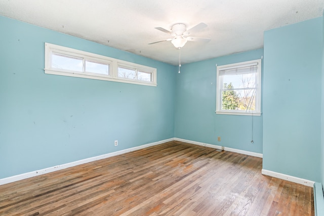 empty room featuring ceiling fan, hardwood / wood-style flooring, and a textured ceiling