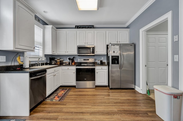 kitchen featuring sink, white cabinetry, stainless steel appliances, crown molding, and light hardwood / wood-style flooring