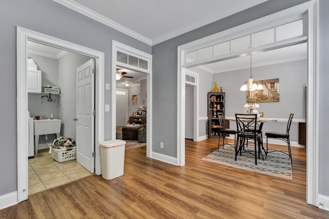 dining area with ornamental molding, hardwood / wood-style floors, and ceiling fan with notable chandelier