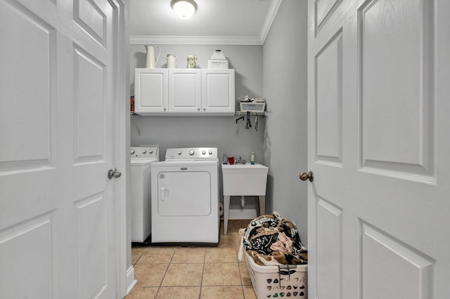 washroom with cabinets, ornamental molding, light tile patterned flooring, sink, and washer and clothes dryer