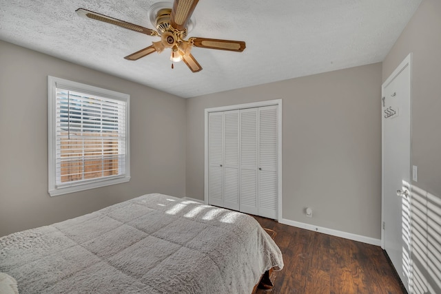 bedroom with a textured ceiling, ceiling fan, dark hardwood / wood-style floors, and a closet