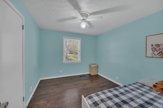 bedroom featuring ceiling fan, dark hardwood / wood-style floors, and a textured ceiling