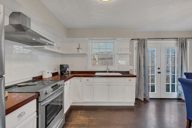 kitchen with dark hardwood / wood-style flooring, sink, white cabinets, wall chimney exhaust hood, and stainless steel electric stove