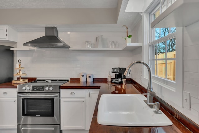 kitchen with wooden counters, wall chimney exhaust hood, and stainless steel electric range oven