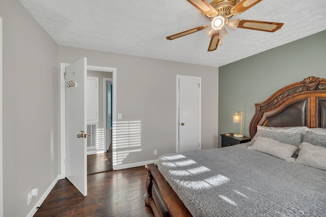 bedroom with ceiling fan, a textured ceiling, and dark hardwood / wood-style flooring