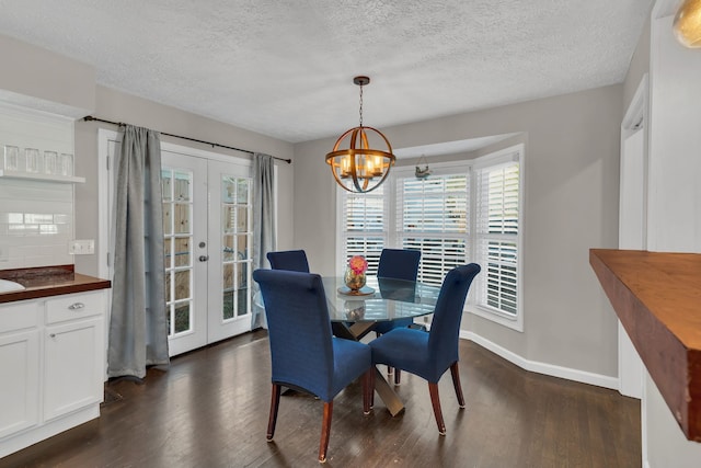 dining room with an inviting chandelier, french doors, dark hardwood / wood-style floors, and a textured ceiling