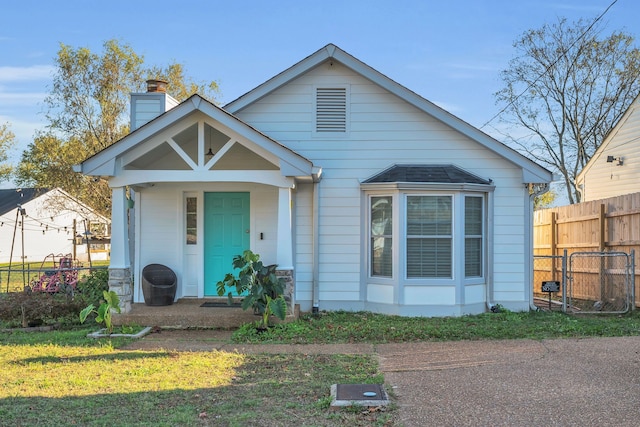 bungalow-style house featuring a front lawn