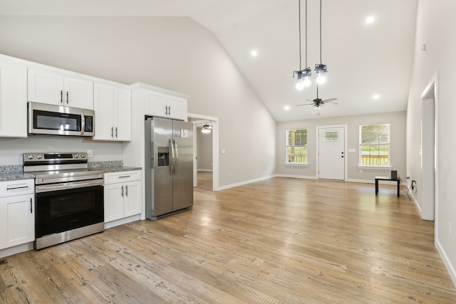 kitchen featuring light hardwood / wood-style floors, stainless steel appliances, white cabinets, high vaulted ceiling, and ceiling fan