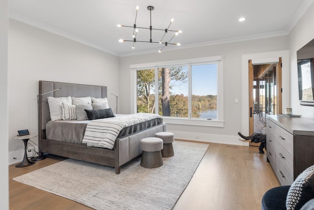 bedroom with an inviting chandelier, light wood-type flooring, and crown molding