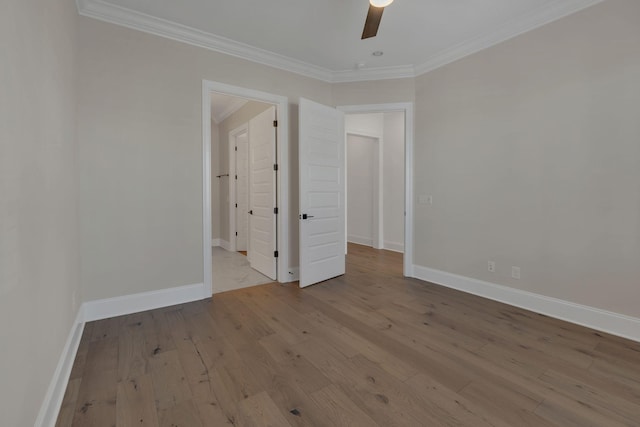 unfurnished bedroom with ornamental molding, wood-type flooring, and baseboards