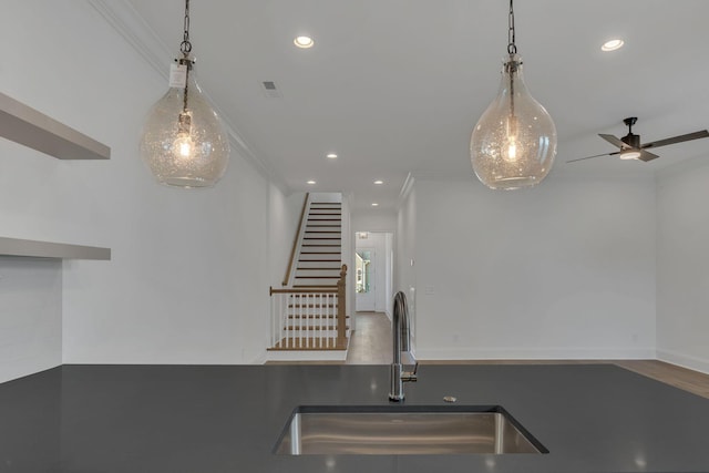 kitchen featuring ornamental molding, a sink, and recessed lighting