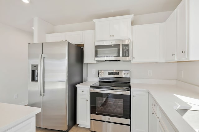 kitchen featuring light hardwood / wood-style flooring, white cabinets, and stainless steel appliances