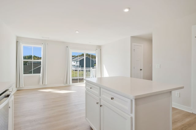 kitchen featuring a center island, light hardwood / wood-style flooring, white cabinets, and plenty of natural light