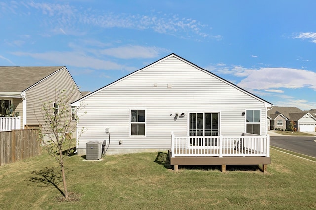 rear view of property with a yard, a deck, and central air condition unit