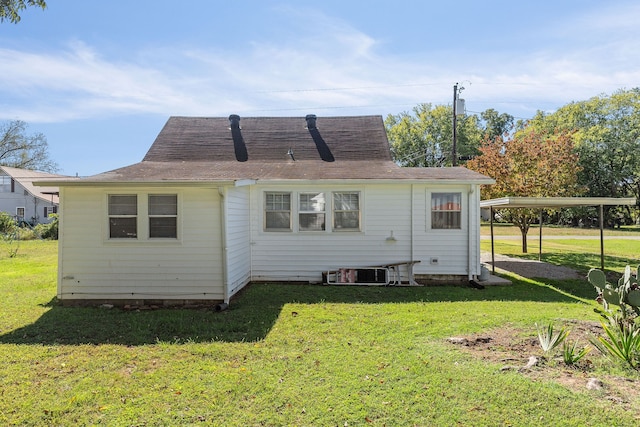 rear view of house featuring cooling unit and a lawn