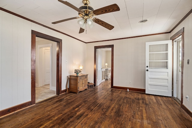 unfurnished bedroom with wood walls, crown molding, dark hardwood / wood-style floors, and ceiling fan